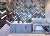 Thumbnail 28 of 54 - a kitchen with blue cabinets and a stainless steel sink and a checkered wall