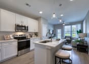 Thumbnail 47 of 54 - an open kitchen and living room with white cabinets and a counter top