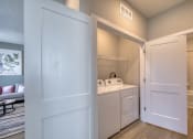 Thumbnail 49 of 54 - a laundry room with a washer and dryer and a door to a bathroom