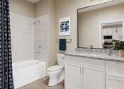 Thumbnail 5 of 30 - a bathroom with a large mirror and a toilet and a tub