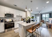 Thumbnail 54 of 62 - A modern kitchen with white cabinets and a large island.