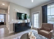 Thumbnail 53 of 62 - A living room with a brown chair and a black cabinet.