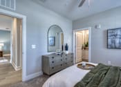 Thumbnail 57 of 62 - A bedroom with a large bed and a dresser with a mirror above it.