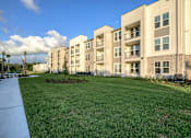 Thumbnail 40 of 62 - Apartment complex with a green lawn in front.