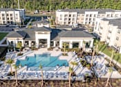Thumbnail 28 of 62 - A large white building with a pool in front.