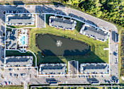 Thumbnail 30 of 62 - An aerial view of a large complex with a lake in the middle.