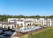 Thumbnail 35 of 62 - A large white building with a pool in front.