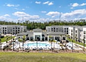 Thumbnail 34 of 62 - A large building complex with a pool in the middle.