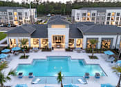 Thumbnail 26 of 62 - A large white building with a pool in front.