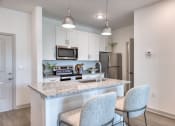 Thumbnail 8 of 92 - a kitchen with granite counter tops and a bar with two chairs