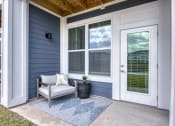 Thumbnail 7 of 92 - the front porch of a home with a chair and a plant