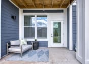 Thumbnail 71 of 92 - a front porch with a chair and a rug and a door