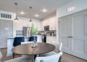 Thumbnail 81 of 92 - a kitchen and dining room with white cabinets and a table