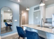 Thumbnail 79 of 92 - a kitchen with blue chairs and a marble counter top