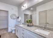 Thumbnail 88 of 92 - a bathroom with white cabinets and granite counter tops and a large mirror