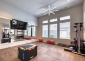 Thumbnail 69 of 92 - a home gym with a tv and exercise equipment