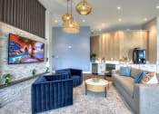 Thumbnail 59 of 92 - a living room with blue couches and chairs and a fireplace