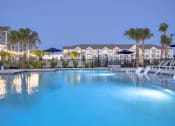 Thumbnail 44 of 92 - a large swimming pool with palm trees and buildings in the background