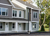Thumbnail 3 of 22 - A grey house with white trim and a black roof.