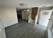 Thumbnail 8 of 22 - A room with a staircase and a white door.