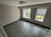 Thumbnail 6 of 22 - A room with a window and a wooden floor.