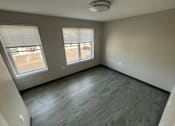 Thumbnail 9 of 22 - A room with grey flooring and two windows.