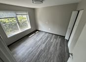 Thumbnail 19 of 22 - A room with a window and a wooden floor.