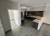 Thumbnail 17 of 22 - A kitchen with a sink and a refrigerator.
