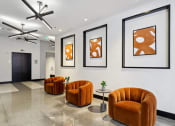 Thumbnail 34 of 50 - a lobby with orange chairs and pictures on the wall at The Zenith, Baltimore, Maryland