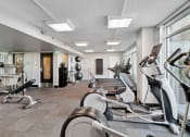 Thumbnail 29 of 50 - a gym with various exercise machines and windows at The Zenith, Baltimore, MD, 21201