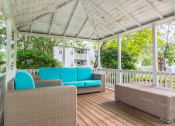 Thumbnail 26 of 28 - a wraparound porch with wicker furniture and a white pergola at Hamilton at Kings Place, Columbia, MD 21046
