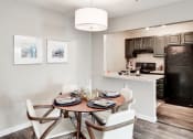 Thumbnail 7 of 28 - a dining area with a table and chairs and a kitchen in the background at Hamilton at Kings Place, Columbia Maryland