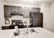 Thumbnail 6 of 28 - a kitchen with gray cabinets and white countertops at Hamilton at Kings Place, Columbia, MD 21046
