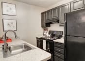 Thumbnail 5 of 28 - a kitchen with black appliances and white granite countertops at Hamilton at Kings Place, Maryland, 21046