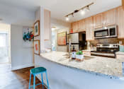 Thumbnail 12 of 33 - a kitchen with a granite counter top and stainless steel appliances at Ellicott Grove, Maryland