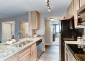 Thumbnail 10 of 33 - a kitchen with wood cabinets and granite countertops at Ellicott Grove, Ellicott City, 21043