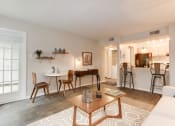 Thumbnail 13 of 35 - a living room with a couch a table and chairs and a kitchen in the background at Madison at Eden Brook, Columbia Maryland