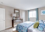 Thumbnail 15 of 33 - a bedroom with a bed and a dresser with a mirror at Ellicott Grove, Ellicott City