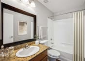 Thumbnail 12 of 54 - a bathroom with a white shower and a sink and a mirror at Villages at Morgan Metro, Landover Maryland