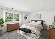 Thumbnail 12 of 40 - Modern bedroom with gray carpet and wood furniture at The Brook At Columbia Apartments, Maryland