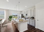 Thumbnail 2 of 30 - an open kitchen and dining room with white cabinets and a marble counter top at Refinery Row, Baltimore, 21224