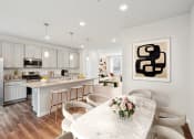 Thumbnail 3 of 30 - an open kitchen and dining room with white cabinets and a marble table at Refinery Row, Baltimore, MD 21224