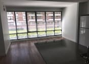Thumbnail 3 of 8 - A room with a large window overlooking a building.