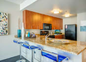 Thumbnail 18 of 50 - Gourmet kitchens with Giallo St. Cecilia Gold granite countertops and cherry cabinetry with chrome hardware at The Zenith, Baltimore