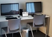 Thumbnail 8 of 8 - Two computer monitors and a Wi-Fi sign on a desk.