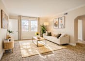 Thumbnail 1 of 24 - A living room with a white couch, a coffee table, and a rug ighland Ridge Apartments, Capitol Heights, MD, 20743