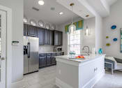 Thumbnail 5 of 48 - A kitchen with a white island and stainless steel appliances at Ellicott Grove, Ellicott City, MD 21043
