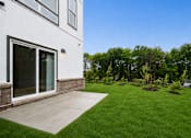Thumbnail 8 of 8 - A white house with a green lawn in front.