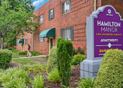 Thumbnail 12 of 18 - a brick building with a sign apartments at Hamilton Manor Apartments, Maryland