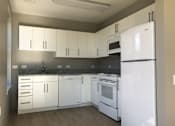 Thumbnail 3 of 10 - A kitchen with white appliances and cabinets.